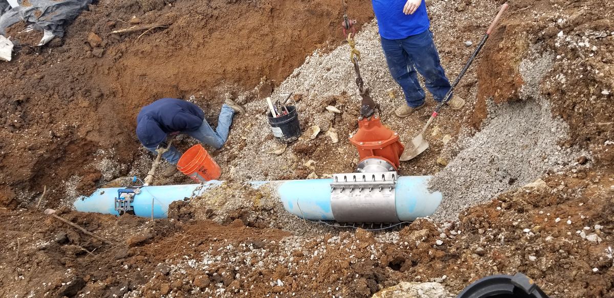 Crew installing underground utility piping